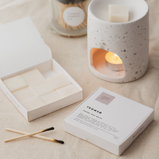 TROMSO wax melts box, with an open box of melts next to it, and a wax melt burner with a lit candle