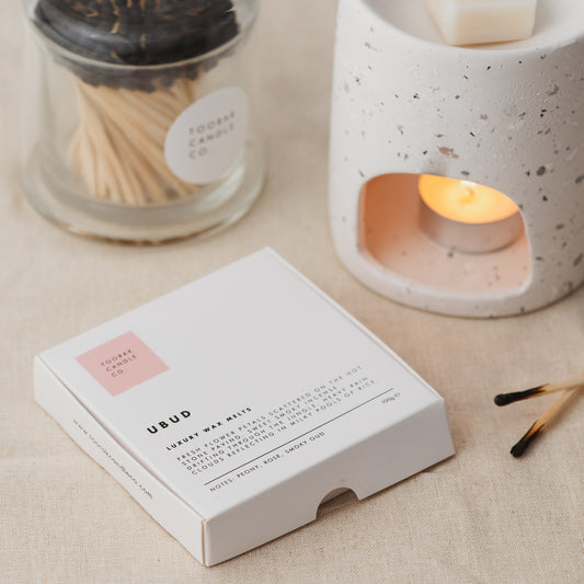 UBUD wax melts with ceramic wax melt burner, and branded grey-tipped matches