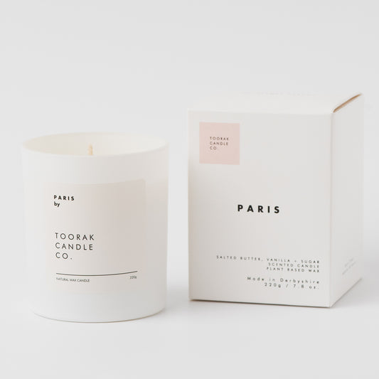 White crossaint candle with 'Paris by Toorak Candle Co.' text next to its packaging on a white background