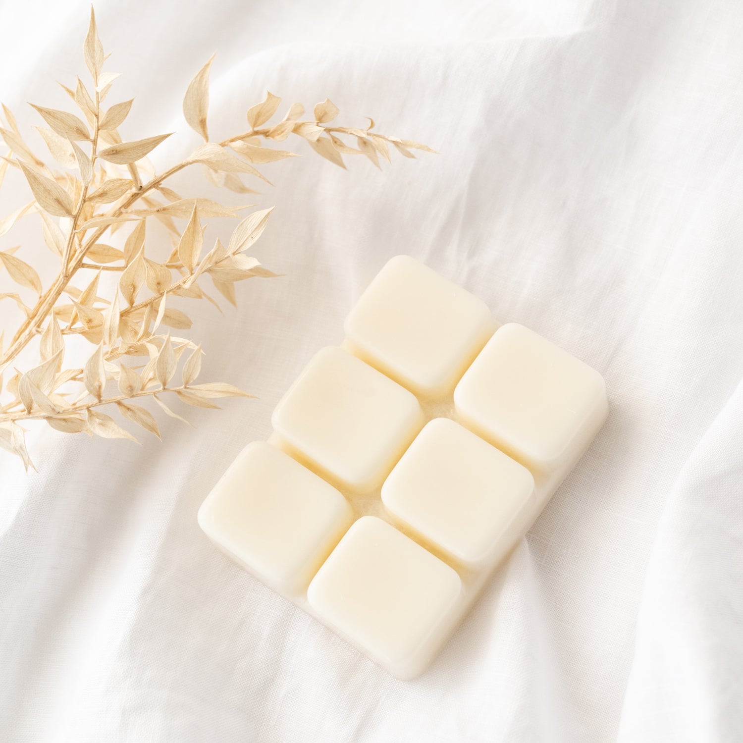 6 cube white wax melt against white background with cream flowers